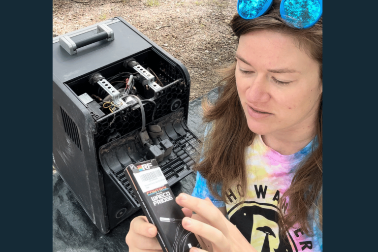 Tee Corley holding a replacement Waeco thermistor in front of her Dometic CFX refrigerator